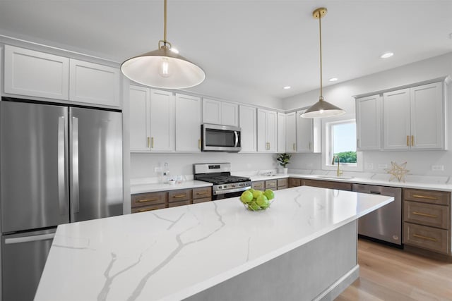 kitchen featuring light stone countertops, pendant lighting, and appliances with stainless steel finishes