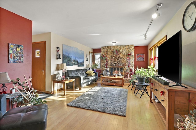 living room featuring light hardwood / wood-style floors, a fireplace, and track lighting