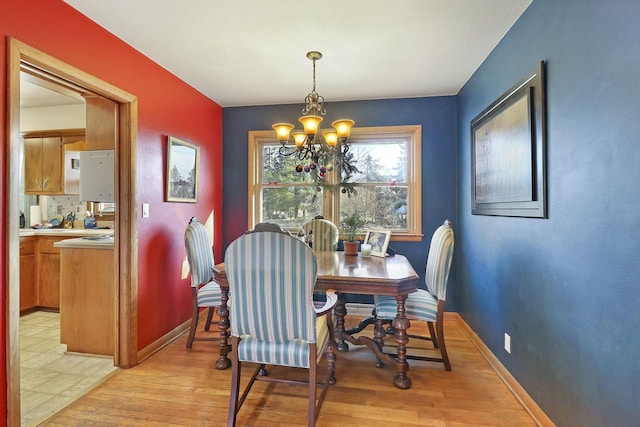 dining area featuring light hardwood / wood-style floors and an inviting chandelier