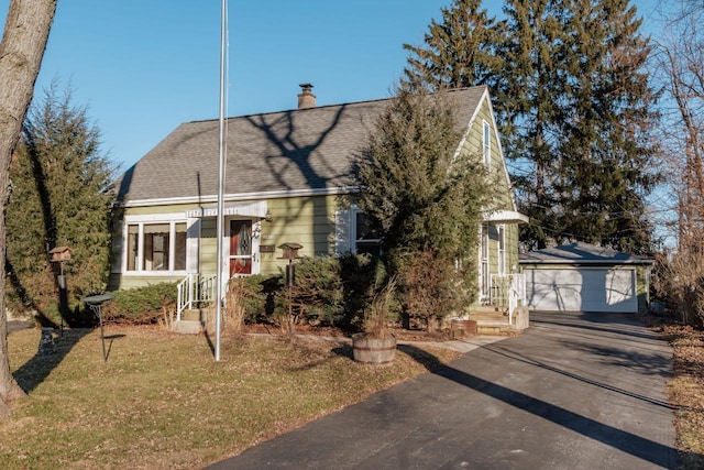 view of front facade featuring an outbuilding, a garage, and a front yard