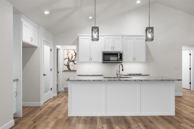 kitchen featuring sink, white cabinets, and decorative light fixtures