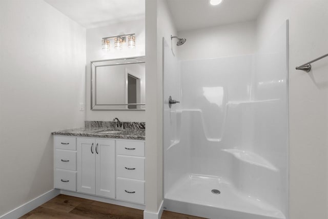 bathroom featuring vanity, a shower, and wood-type flooring