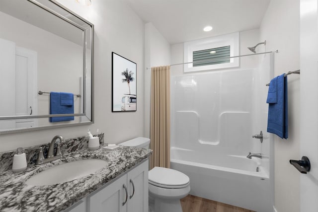 full bathroom featuring shower / bath combo with shower curtain, vanity, wood-type flooring, and toilet