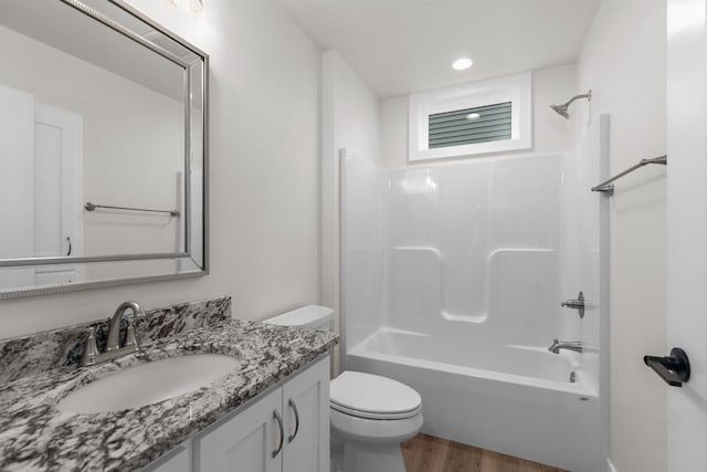 full bathroom with hardwood / wood-style floors, vanity, toilet, and shower / washtub combination