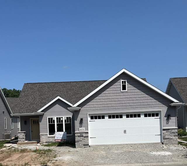 craftsman-style house featuring central AC and a garage