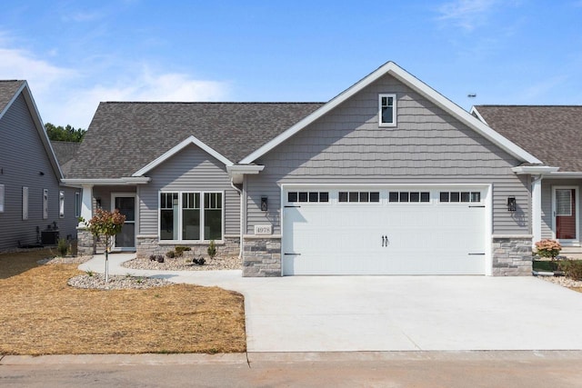 craftsman-style house featuring central AC unit and a garage