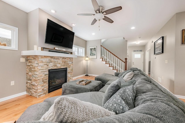 living room with a fireplace, wood-type flooring, and ceiling fan