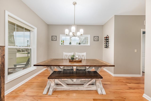 dining room with light hardwood / wood-style flooring and an inviting chandelier