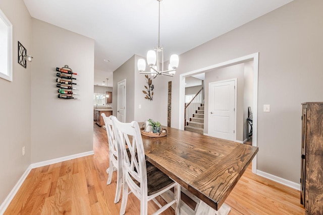 dining area with light hardwood / wood-style flooring and a chandelier