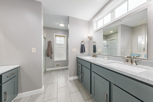 bathroom with tiled shower and vanity