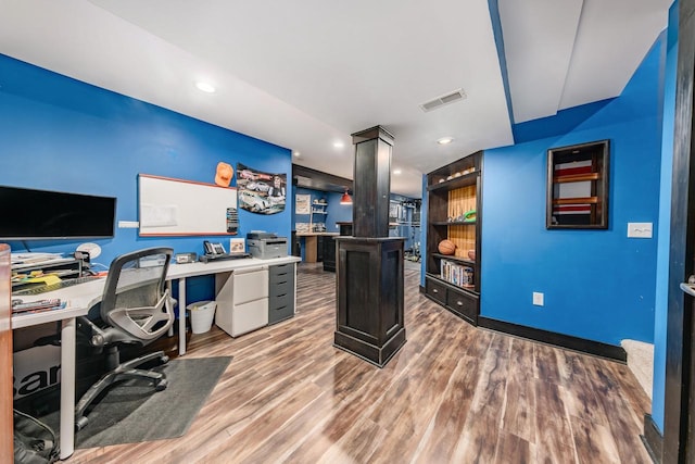 office featuring built in features and hardwood / wood-style floors