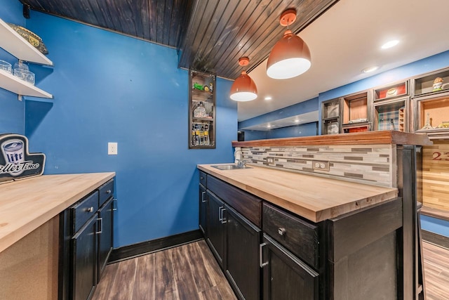 bar featuring wooden counters, pendant lighting, dark hardwood / wood-style flooring, and sink