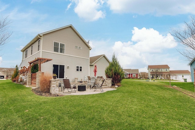 rear view of property with a patio area, a yard, and an outdoor fire pit