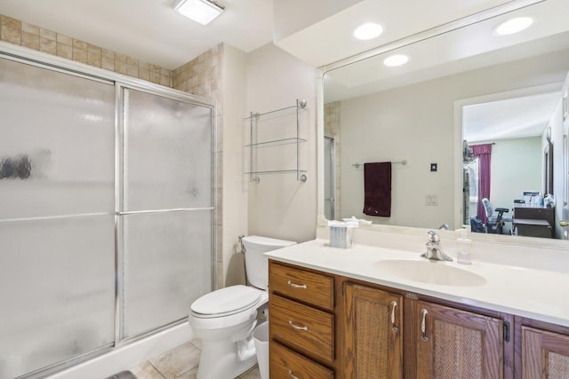 bathroom with vanity, a shower with shower door, tile patterned floors, and toilet