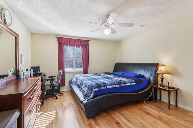 bedroom with ceiling fan, a textured ceiling, and light wood-type flooring