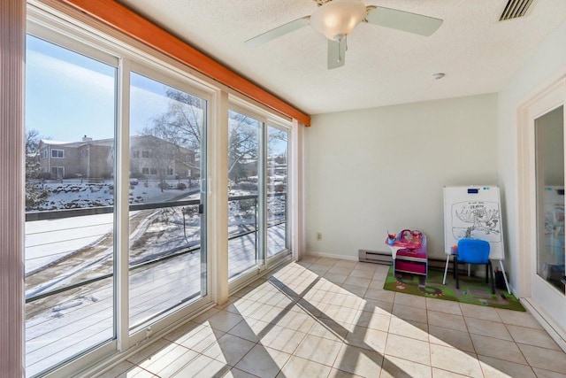 interior space featuring ceiling fan, a textured ceiling, and light tile patterned floors