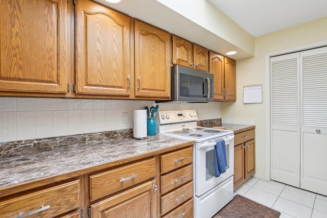 kitchen with light tile patterned floors, decorative backsplash, and white range with electric stovetop