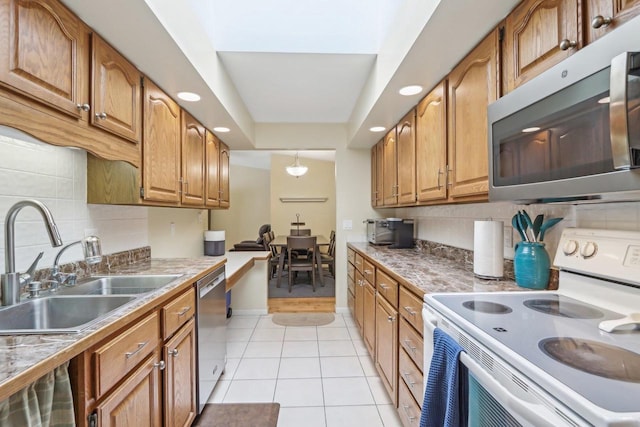 kitchen featuring appliances with stainless steel finishes, sink, decorative backsplash, and light tile patterned floors