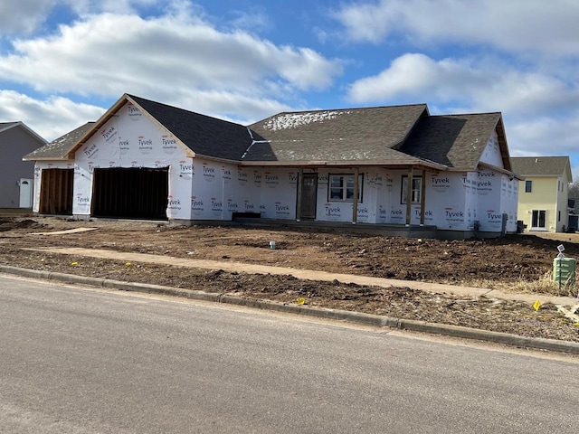 property under construction with covered porch and a garage