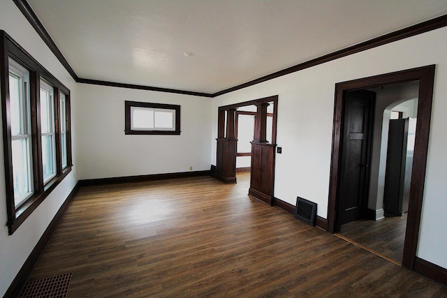 unfurnished room featuring dark hardwood / wood-style flooring, plenty of natural light, and ornamental molding