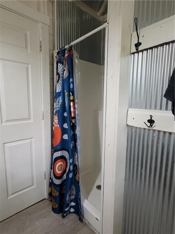 bathroom featuring a shower with shower curtain and wood-type flooring