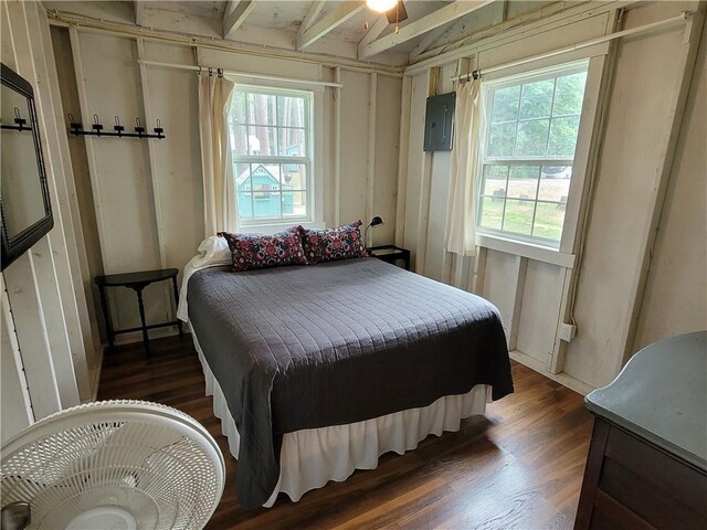 bedroom with ceiling fan, beam ceiling, dark hardwood / wood-style flooring, and electric panel