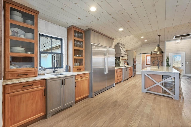 kitchen with sink, stainless steel built in refrigerator, hanging light fixtures, and wood ceiling