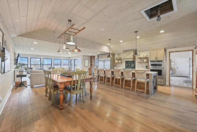 dining room with light wood-type flooring, vaulted ceiling, and wood ceiling