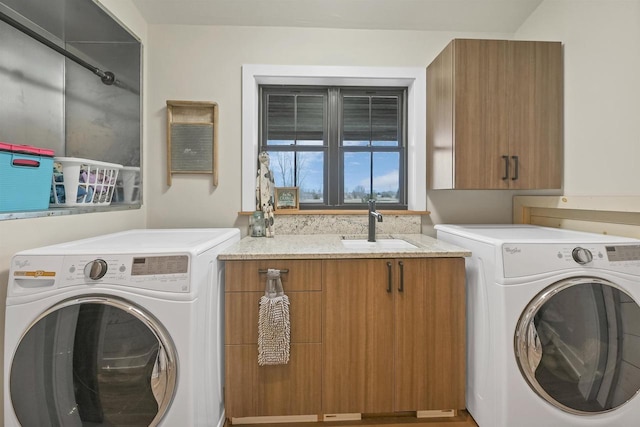 laundry room featuring cabinets, sink, and washer and dryer