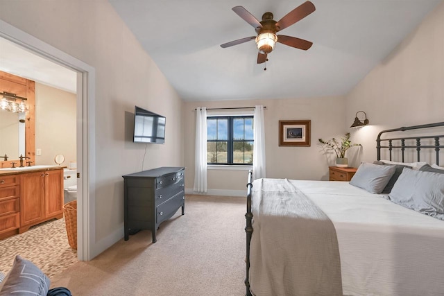 bedroom with lofted ceiling, light carpet, sink, ensuite bath, and ceiling fan