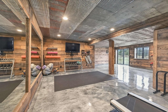 unfurnished living room with wood walls and concrete flooring