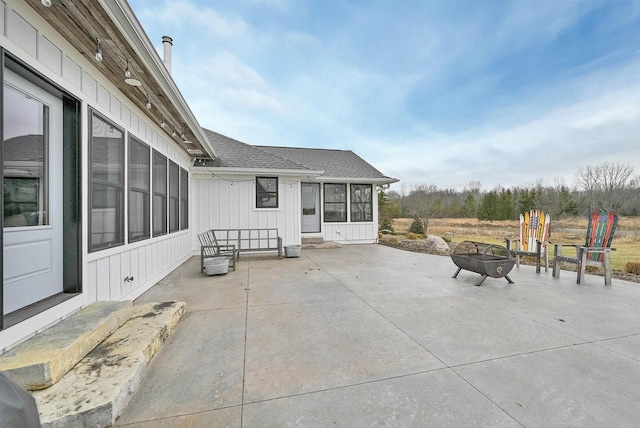 view of patio / terrace with a fire pit and a sunroom