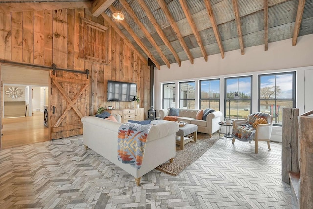 living room featuring wooden walls, beam ceiling, a barn door, high vaulted ceiling, and light parquet flooring