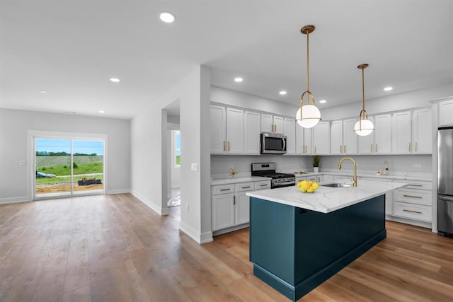 kitchen featuring white cabinets, hanging light fixtures, sink, and appliances with stainless steel finishes