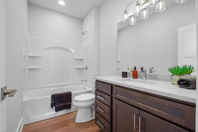 full bathroom with shower / bathing tub combination, vanity, hardwood / wood-style flooring, and toilet