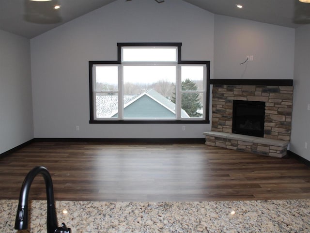 W4241 Hilltop Dr, Fond Du Lac, WI 54937 - unfurnished living room featuring dark hardwood / wood-style floors, a stone fireplace, and vaulted ceiling
