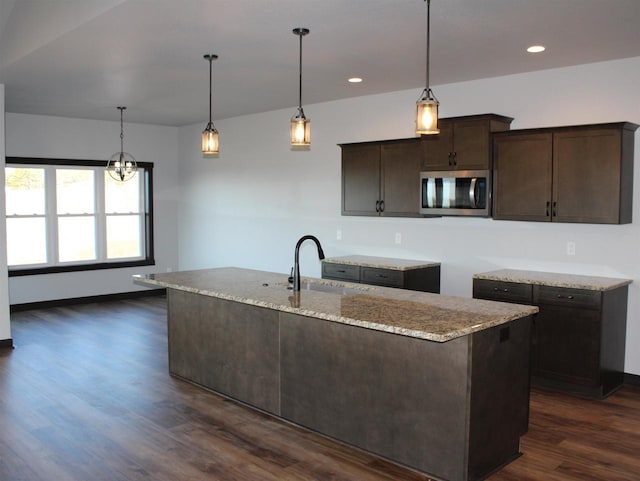W4241 Hilltop Dr, Fond Du Lac, WI 54937 - kitchen with light stone countertops, pendant lighting, dark brown cabinets, and sink