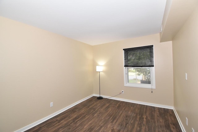 unfurnished room with dark wood-type flooring