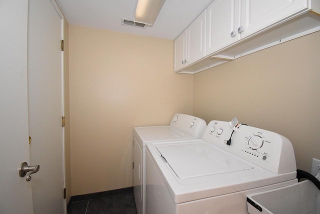 laundry room featuring cabinets, washing machine and dryer, and tile patterned floors