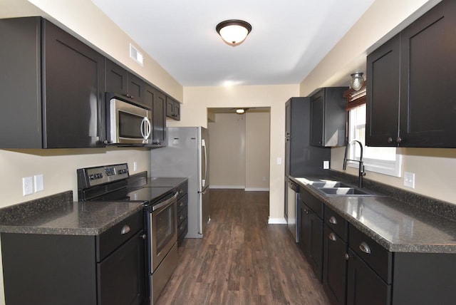 kitchen with appliances with stainless steel finishes, dark wood-type flooring, and sink