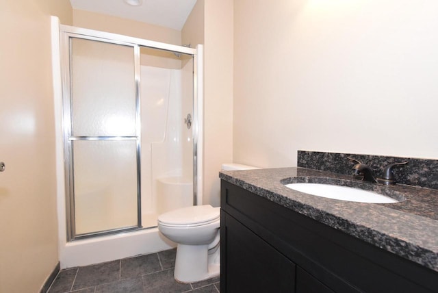 bathroom with vanity, toilet, and a shower with door