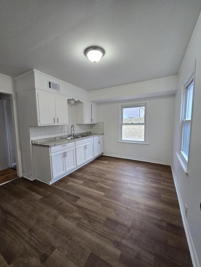 kitchen with white cabinets, sink, backsplash, and dark wood-type flooring