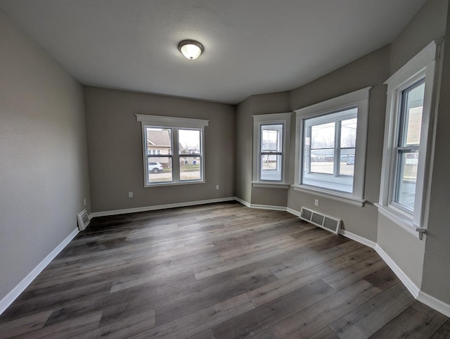 unfurnished room with dark hardwood / wood-style flooring