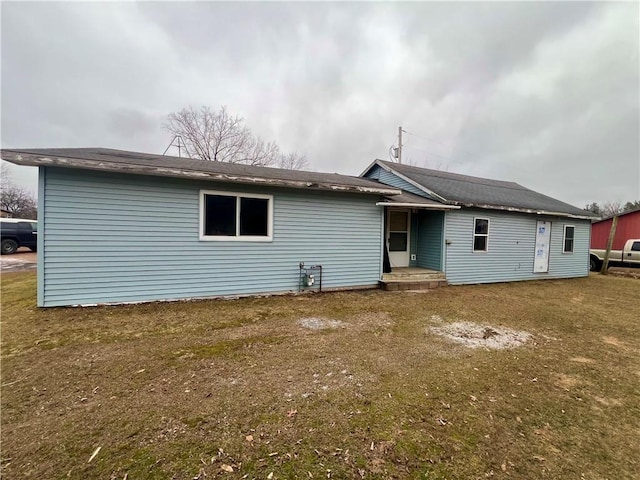 rear view of property with a lawn