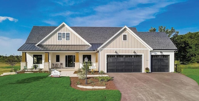 view of front facade with covered porch, a garage, and a front yard