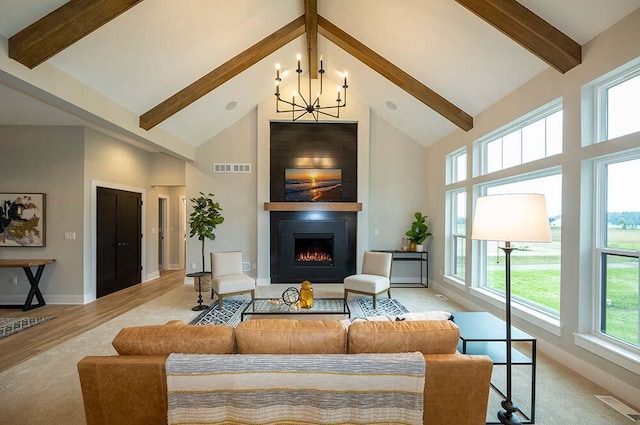 living room featuring beam ceiling, high vaulted ceiling, light hardwood / wood-style flooring, a notable chandelier, and a fireplace