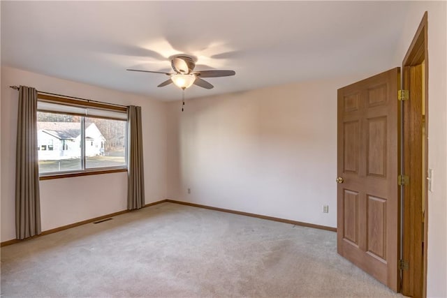 empty room with ceiling fan and light colored carpet