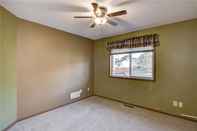 empty room featuring ceiling fan and light carpet