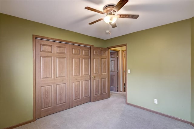 unfurnished bedroom featuring ceiling fan, light carpet, and a closet