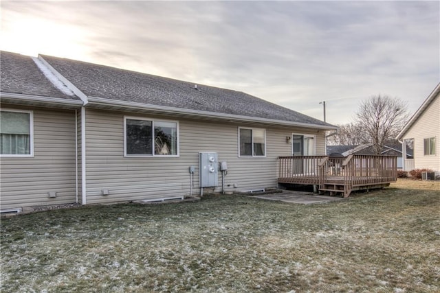 back of property with central AC, a yard, and a deck